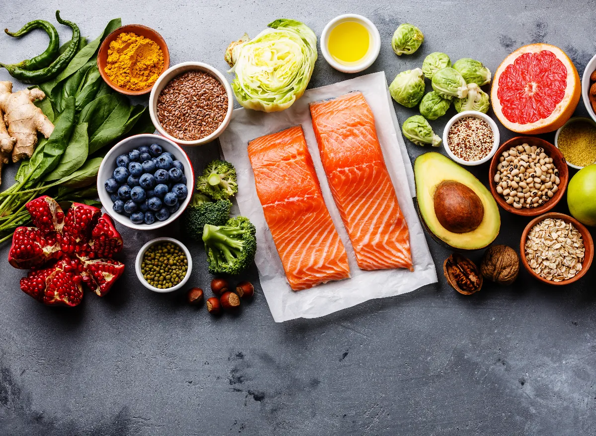 A table full of healthy food on top, including raw fish, fruits and vegetables