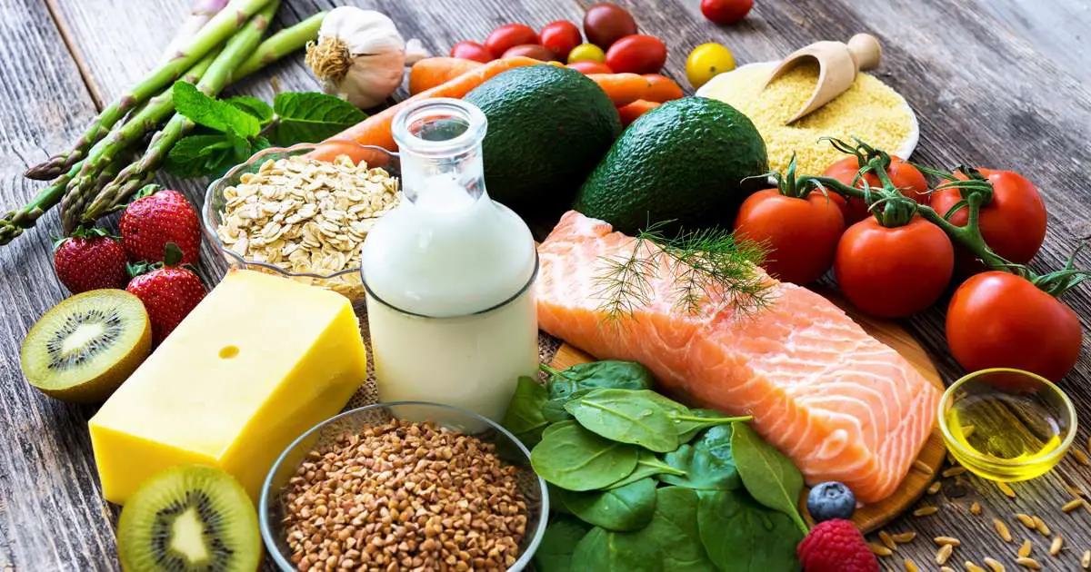 A table full of healthy food on top, including raw fish, fruit, vegetables and dairy